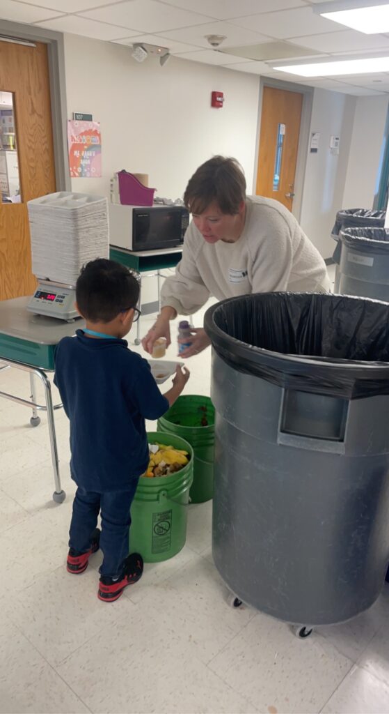 teacher and student learning to recycle and compost lunch waste