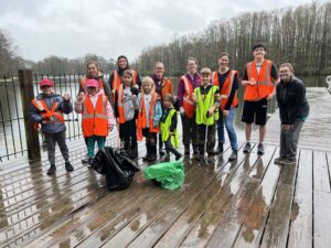 youth and adults posing for a picture after cleaning up a lake