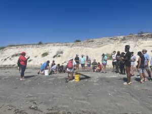 students standing in sand listening to lesson