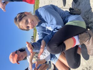 youth holding a snail upside down on the palm of her hand