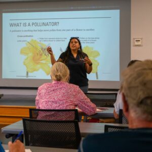 Gabriella speaking to room of participants during pollinator impact presentation
