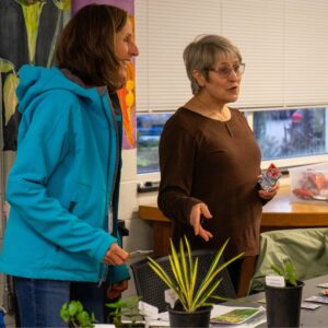 Master Gardener trainees discuss the propagations brought in for class 